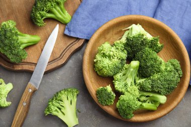 Taze yeşil brokoli gri masada, düz yatıyordu.