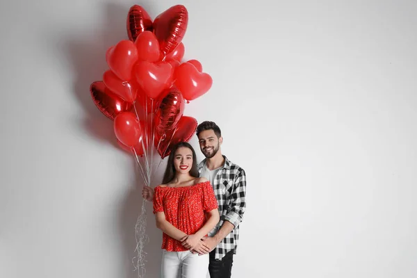 Happy Young Couple Heart Shaped Balloons Light Background Valentine Day — Stock Photo, Image