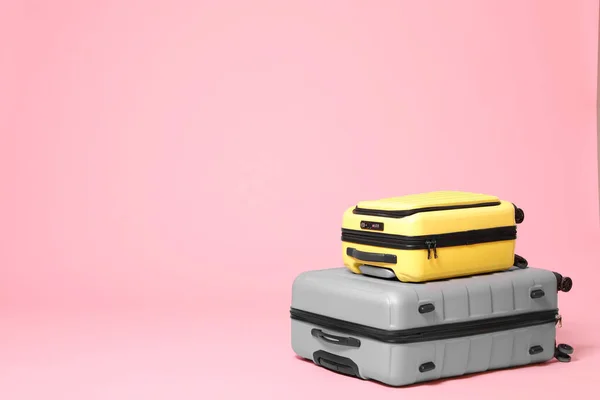 Pembe arka planda şık sarı ve gri bavullar. Bunun için boşluk — Stok fotoğraf