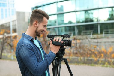 Şehir caddesinde çalışan kameralı bir video operatörü