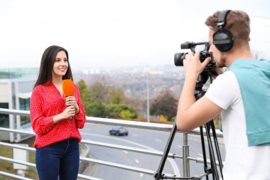 Şehir caddesinde çalışan genç gazeteci ve video operatörü