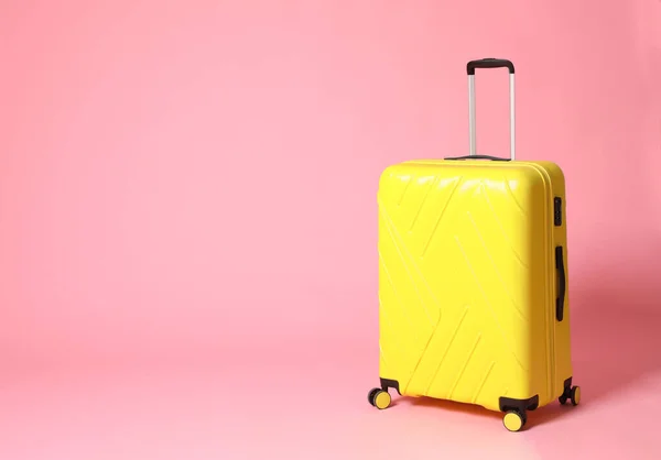 Snygg gul resväska på rosa bakgrund. Plats för text — Stockfoto