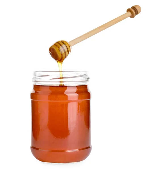 Glass jar of wildflower honey and wooden dipper isolated on whit — Stock Photo, Image