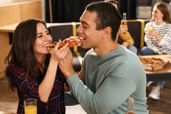 一对年轻夫妇在咖啡馆里吃着美味的披萨 — 图库照片