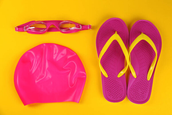 Плоская композиция с плавательными принадлежностями на желтом фоне

