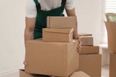Odasında karton kutular olan bir adam, yakın plan. Taşıma servisi
