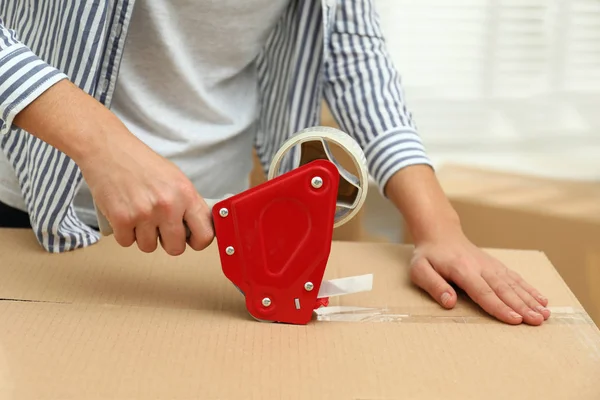 Woman packing cardboard box indoors, closeup. Moving day — Stock Photo, Image