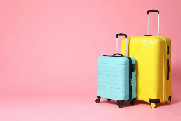 Stylowe żółte i turkusowe walizki na różowym tle. Kosmos — Zdjęcie stockowe