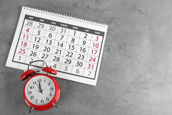 灰色石头背景上的日历和闹钟 — 图库照片
