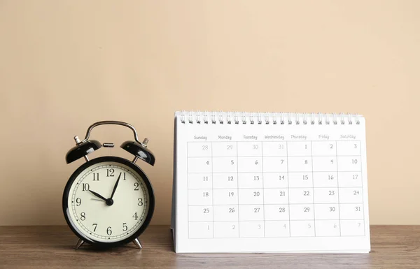 Kalender Och Väckarklocka Träbord Mot Beige Bakgrund — Stockfoto