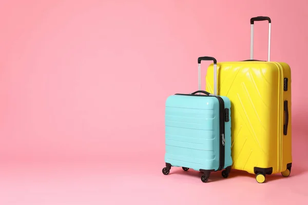 Snygg gul och turkos resväskor på rosa bakgrund. Rymden — Stockfoto