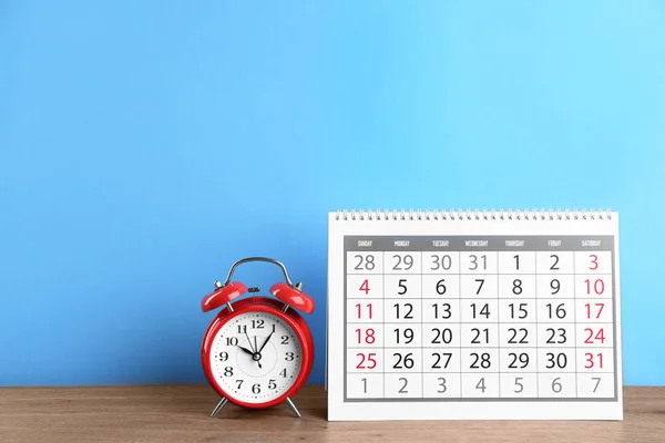 Calendário Despertador Mesa Madeira Contra Fundo Azul Claro — Fotografia de Stock