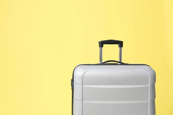 Elegante maleta gris sobre fondo amarillo. Espacio para texto —  Fotos de Stock