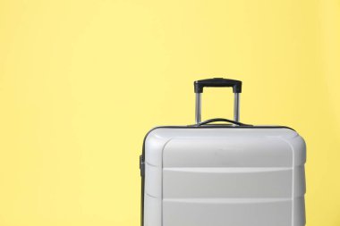 Sarı arka planda şık gri bavul. Metin için alan