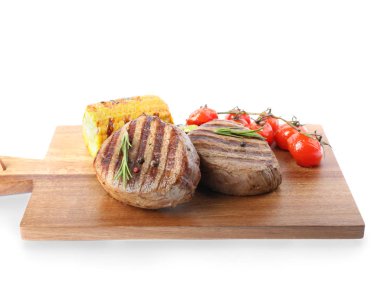 Lezzetli sığır eti madalyonları, beyaz üzerine izole edilmiş sebzelerle servis edilir.