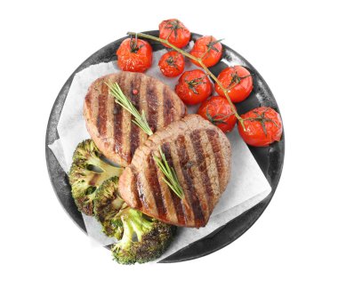 Lezzetli sığır eti madalyonları, beyaz, üst manzara izole edilmiş sebzelerle servis edilir.