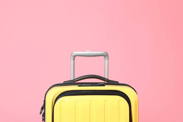 Stylish yellow suitcase packed for travel on pink background — Stock Photo, Image