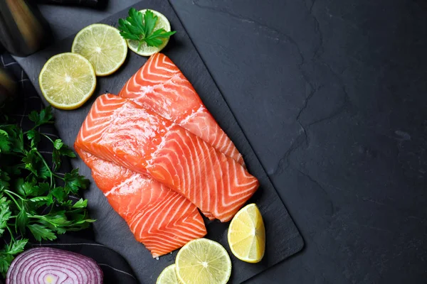 Composição plana com salmão cru fresco e produtos em preto — Fotografia de Stock