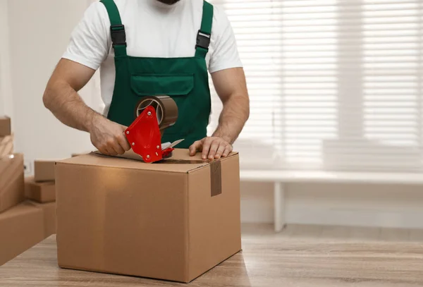 Hombre caja de embalaje con cinta adhesiva en el interior, primer plano. Servicio móvil — Foto de Stock