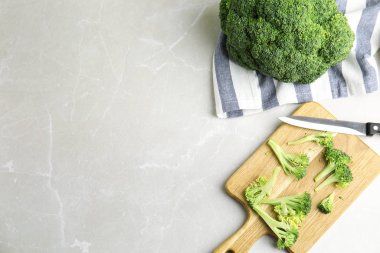Açık gri mermer masa üzerinde çiğ yeşil brokoli, düz. Metin için boşluk