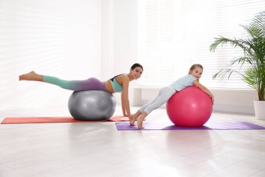 Kadın ve kız evde spor yapıyor.
