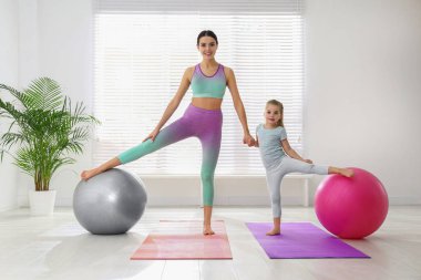Kadın ve kız evde spor yapıyor.