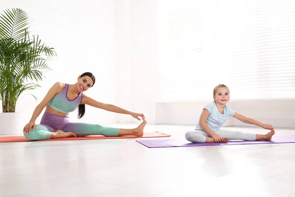女人和女儿在家里一起做瑜伽 健康的生活方式 — 图库照片