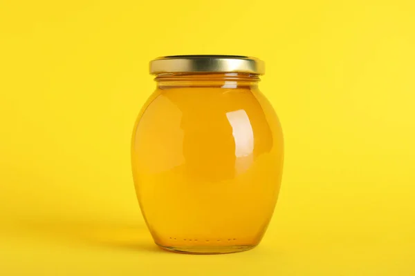 Tarro de miel orgánica sobre fondo amarillo — Foto de Stock