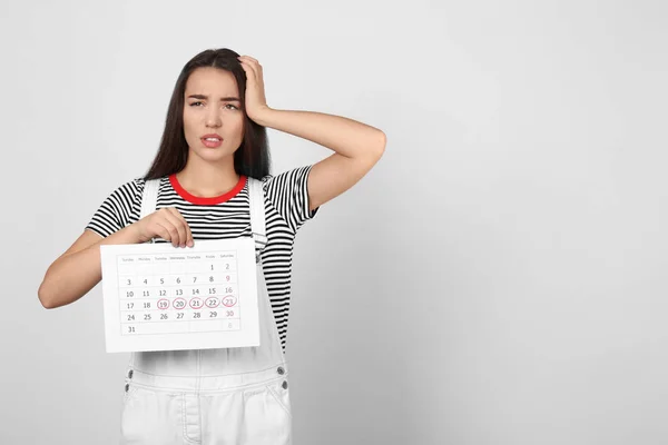 Young Woman Holding Calendar Marked Menstrual Cycle Days Light Background — Stock Photo, Image