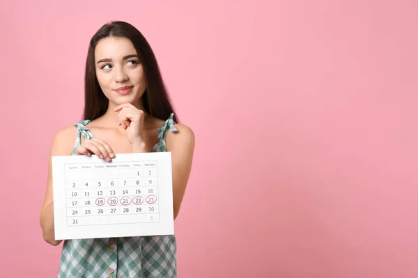 Young Woman Holding Calendar Marked Menstrual Cycle Days Pink Background — Stock Photo, Image