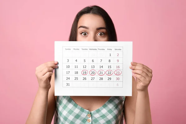 Ung Kvinna Innehav Kalender Med Markerade Menstruationscykel Dagar Rosa Bakgrund — Stockfoto