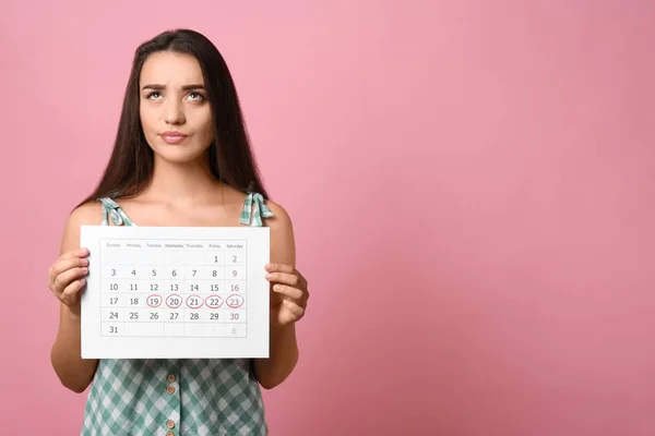 Молодая Женщина Проводит Календарь Отмеченными Менструальным Циклом Дней Розовом Фоне — стоковое фото