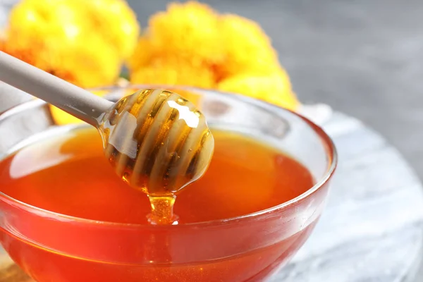 Glass bowl with organic honey and dipper on board, closeup — Stock Photo, Image