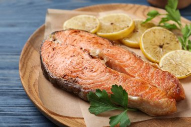 Mavi ahşap masada lezzetli pişmiş kırmızı balık, yakın plan.