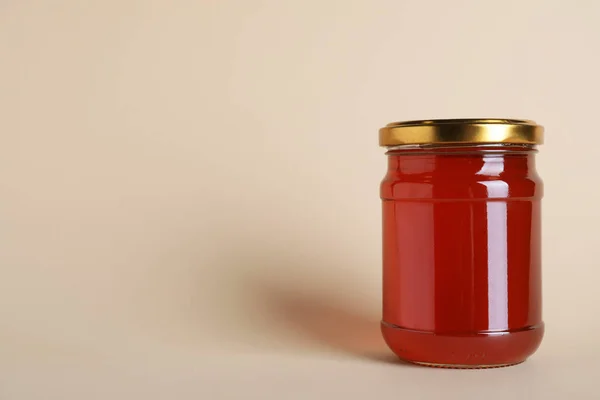 Jar of organic honey on beige background. Space for text — Stock Photo, Image