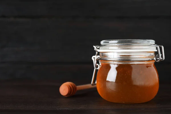 Tarro de miel orgánica sobre mesa de madera sobre fondo oscuro. Sp — Foto de Stock
