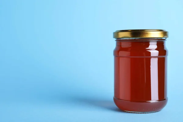 Tarro de miel orgánica sobre fondo azul claro. Espacio para texto — Foto de Stock