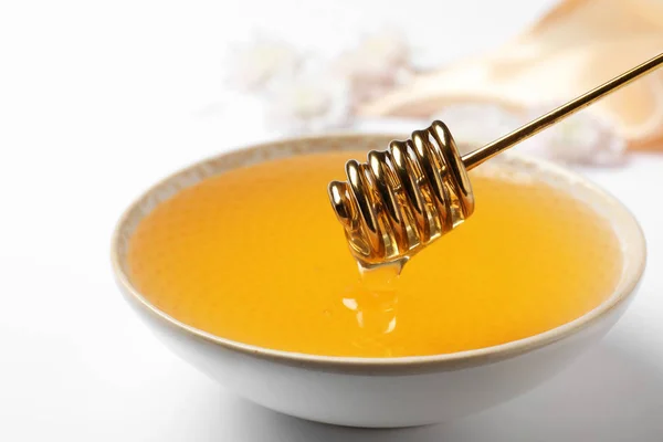Skål med ekologisk honung och dipper på vit bakgrund, närbild — Stockfoto