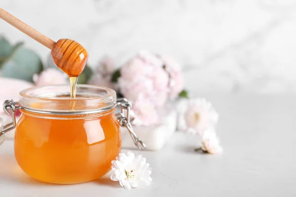 小桌子上放着一罐有机蜂蜜和菊花. Sp — 图库照片