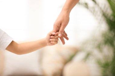 Anne çocuğunu evde tutarken, yakın plan. Mutlu aile