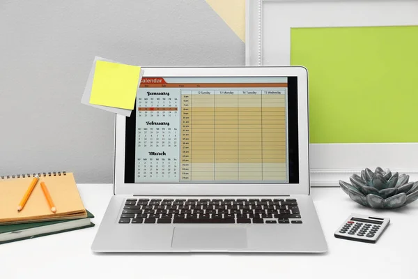 オフィスで画面上のカレンダーと現代のラップトップ — ストック写真