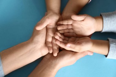 Mavi arka planda el ele tutuşan mutlu aile manzarası