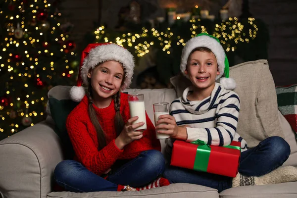 Happy children with glasses of milk at home. Christmas time