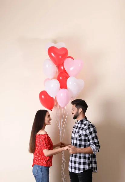 Beautiful Couple Heart Shaped Balloons Beige Background Valentine Day Celebration — Stock Photo, Image