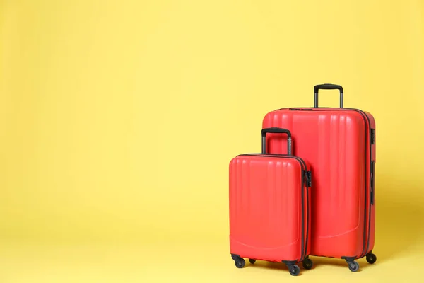Stylové červené kufry na žlutém pozadí. Mezera pro text — Stock fotografie