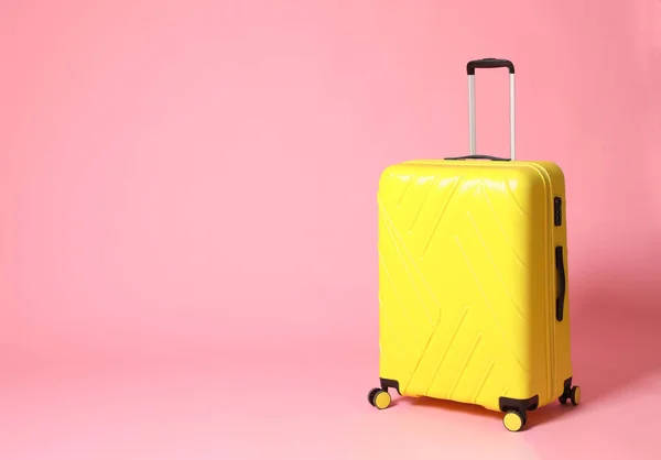 Elegante valigia gialla su sfondo rosa. Spazio per testo — Foto Stock