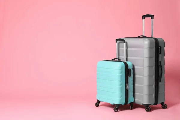 Elegante graue und türkisfarbene Koffer auf rosa Hintergrund. Raum f — Stockfoto