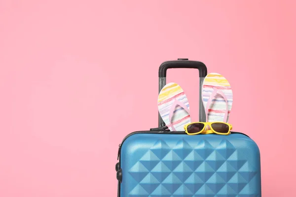 Elegante maleta azul con chanclas y gafas de sol en bac rosa — Foto de Stock