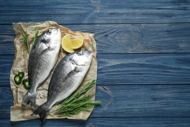 Mavi ahşap masada çiğ dorada balığı, üst manzara. Metin için boşluk