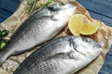 Mavi ahşap masada çiğ balık, yakın plan.